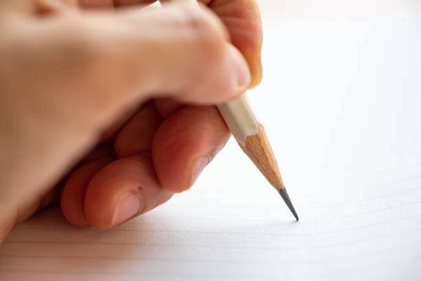 istock Hand writing letter on white paper background, A white pencil, Close up & Macro shot, Selective focus, Stationery concept 1133743406