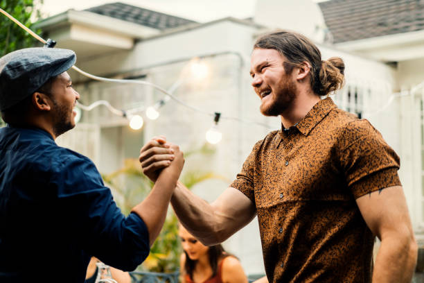 istock Confident male friends holding hands in yard 1133743442
