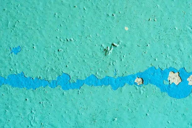 Peeling Blue Aquamarine Color Paint from the Wall. Shattered Plaster Background