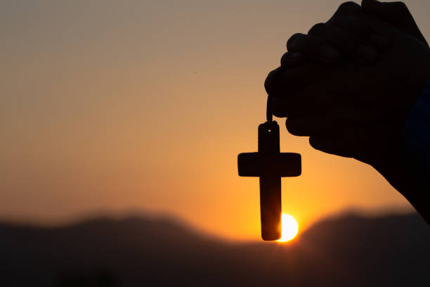 아침에 거룩한 십자가로 기도하는 젊은 남자 - forgiveness praying men silhouette 뉴스 사진 이미지