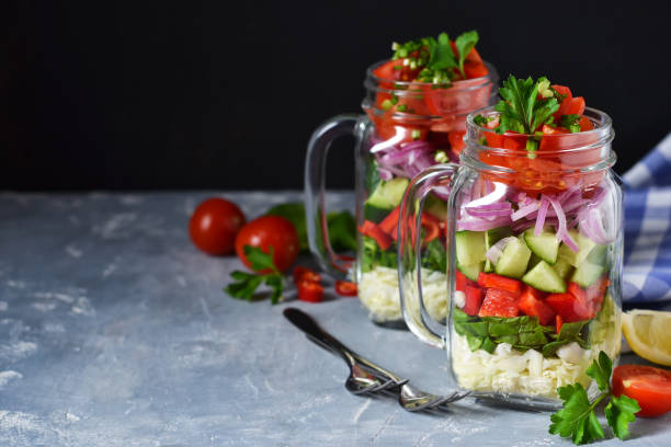 istock Vegetable salad in a glass jar with sauce on a concrete background 1133743910
