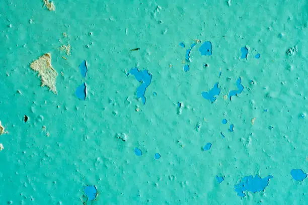 Peeling Blue Aquamarine Color Paint from the Wall. Shattered Plaster Background