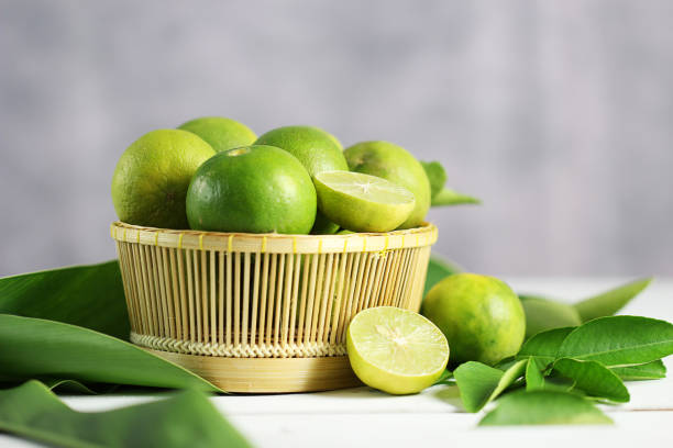 istock Fresh limes on white wooden background. Green limes. 1133744228