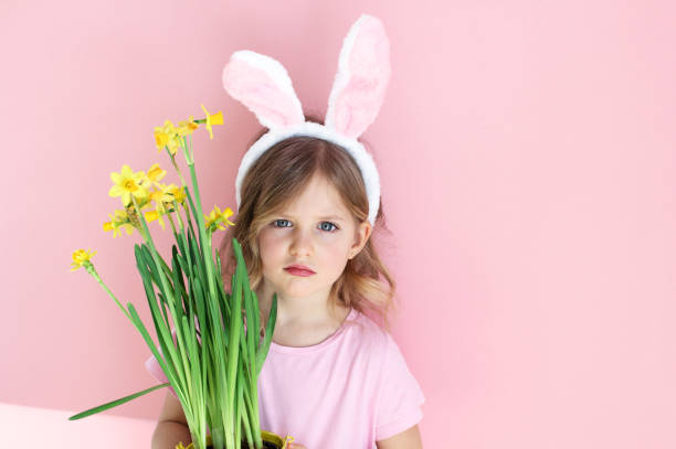 istock Cute little child wearing bunny ears on Easter day on pink background. 1133747718