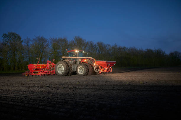 istock Red tractor with sowing machine on a ploughed field 1133750553