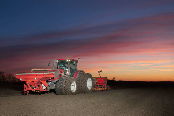 istock Red tractor with sowing machine on a ploughed field 1133750558