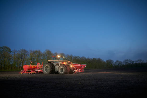 istock Red tractor with sowing machine on a ploughed field 1133750568