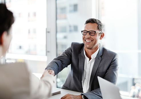 Shot of two businesspeople shaking hands in an office