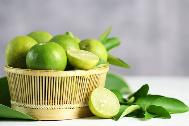 istock Fresh limes on white wooden background. Green limes. 1133751626