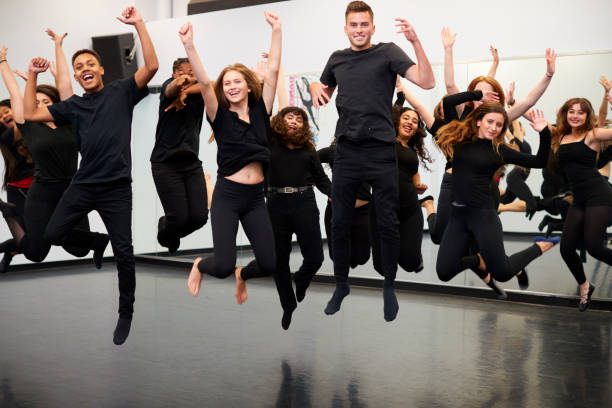 männliche und weibliche studenten an der performing arts school rehearsing street dance im studio - dancing school stock-fotos und bilder