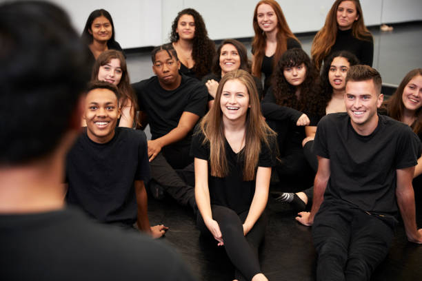 istock Teacher At Performing Arts School Talking To Students Sitting On Floor In Rehearsal Studio 1133752272