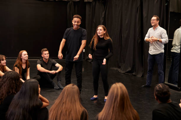 teacher with male and female drama students at performing arts school in studio improvisation class - palco imagens e fotografias de stock