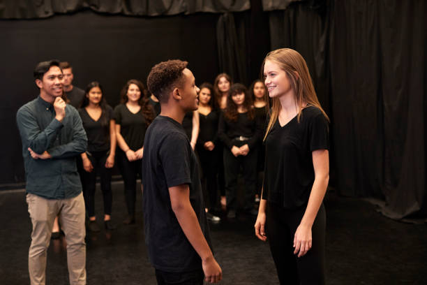 Teacher With Male And Female Drama Students At Performing Arts School In Studio Improvisation Class Teacher With Male And Female Drama Students At Performing Arts School In Studio Improvisation Class actor stock pictures, royalty-free photos & images