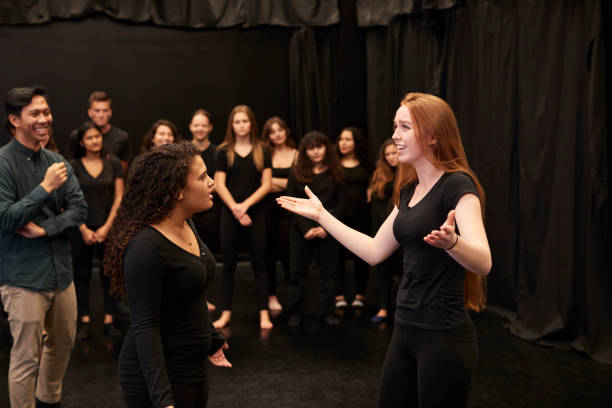 insegnante con studenti di recitazione maschile e femminile alla performing arts school in corso di improvvisazione in studio - improv foto e immagini stock