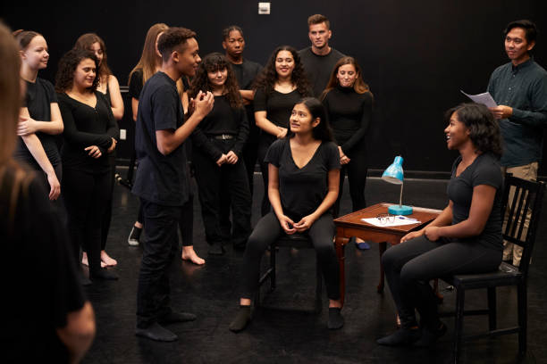 professor com estudantes do drama do macho e da fêmea na escola de artes de execução na classe do improvisation do estúdio - improv - fotografias e filmes do acervo