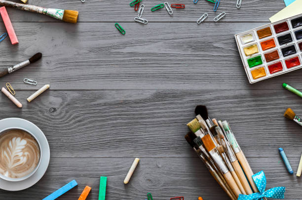 istock Artistic background concept, creative art work accessory colorful supplies set, paint brushes, paints with coffee on grey gray wooden table, drawing lesson education, top view, flat lay, copy space 1133753336