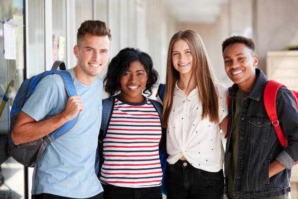 portret uśmiechniętych mężczyzn i kobiet studentów w korytarzu budynku - high school age zdjęcia i obrazy z banku zdjęć