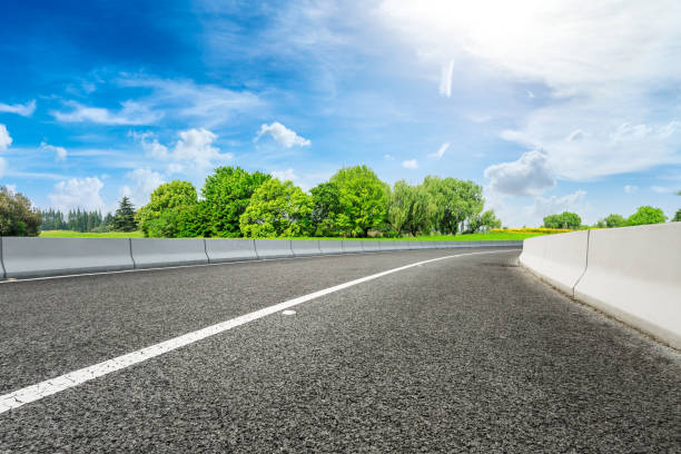 istock Asphalt road and green forest under blue sky 1133754582