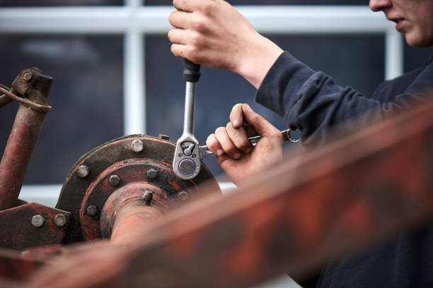 A young farmer repairing farmer equipment