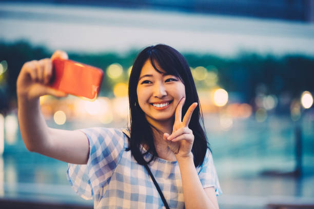 Smiling japanese woman taking selfie