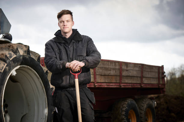 istock Young farmer in front of his blue tractor 1133754959