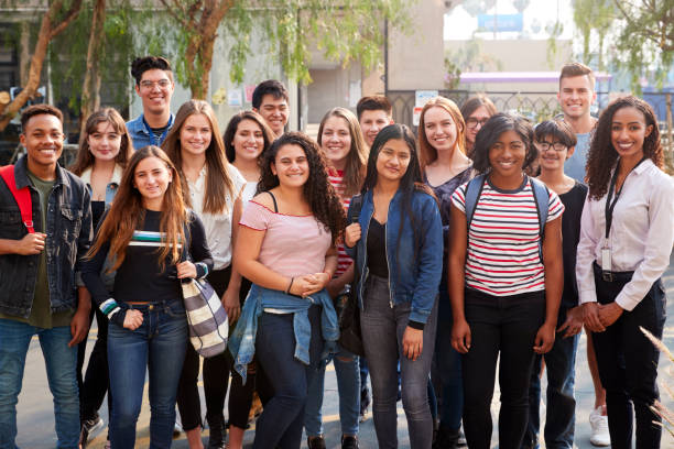 ritratto di studenti universitari maschi e femmine sorridenti con insegnanti fuori dall'edificio scolastico - late teens foto e immagini stock