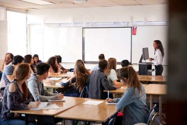 istock Female High School Teacher Standing By Interactive Whiteboard Teaching Lesson 1133755114