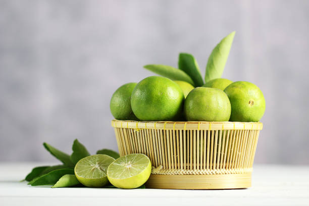 istock Fresh limes on white wooden background. Green limes. 1133758649