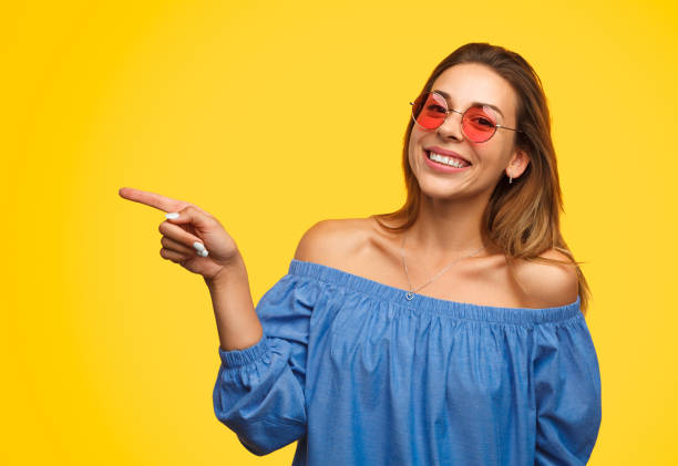 istock Cheerful girl pointing away with smile 1133760162