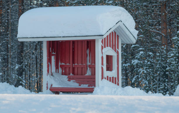 istock Snowcapped red wooden bus stop in typical scandinavian design 1133760619