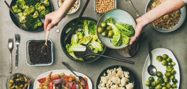健康的なヴィーガン料理と女性の手プレート付き, 広い組成 - salad fruit lettuce spring ストックフォトと画像