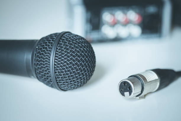istock Black microphone and audio cable, mixer in the blurry background 1133762441