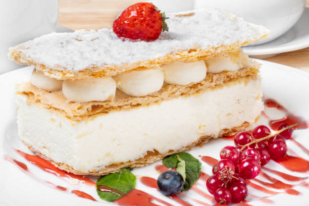 istock Piece of cake with custard and fresh berries on a white plate. 1133762873