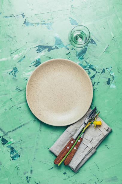 istock Empty beige plate and cutlery with daffodils on a napkin 1133764185