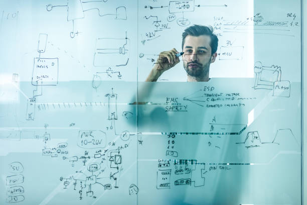 istock Young engineer brainstorming while drawing ideas on a glass in the office. 1133766600