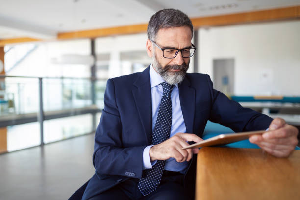 Shot of thinking financial advisor businessman working in office. Shot of thinking financial advisor businessman working at office. business banking analyzing digital tablet stock pictures, royalty-free photos & images