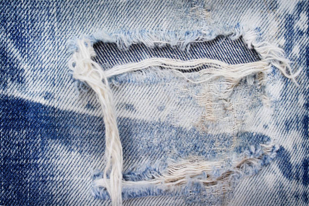 istock Old blue jeans with ripped texture ,  hole and white threads destroyed patterns on denim for background 1133768677