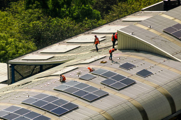 Solar panels being installed on the roof of delhi metro station Delhi, Noida, India - Circa 2019: Solar panels being installed on the roof of the metro station in noida delhi to help provide renewable energy and improve sustainability. Aerial shot of the workers moving on the roof and conducting the installation, wiring and checking of the panels. brics photos stock pictures, royalty-free photos & images