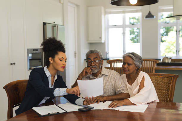 istock Female real estate agent and senior couple discussing over documents 1133772863
