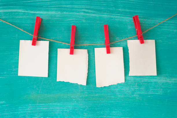 empty, blank slips of paper hanging on a string mounted with clothespins, free copy space