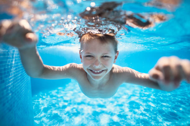 istock Little boy swimming underwater in pool 1133777377