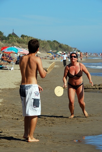 Couple playing bat and ball on Playa de la Vibora beach, Elviria, Marbella, Costa del Sol, Andalusia, Spain, Europe.