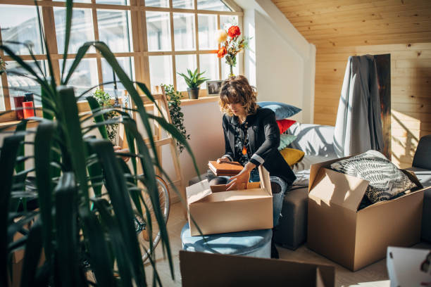 istock Woman unpacking boxes in new home 1133778393