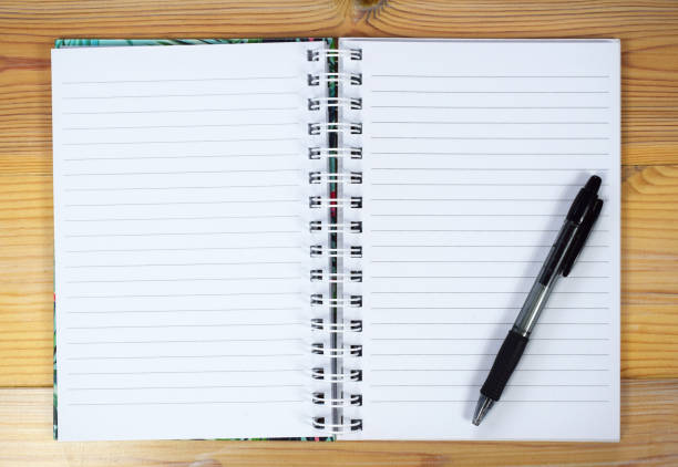istock Notebook and pen on wooden background 1133779107