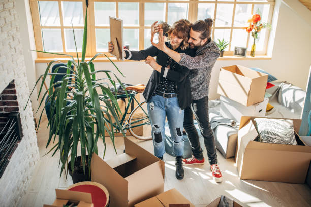 istock Couple in new home looking at framed picture 1133779799
