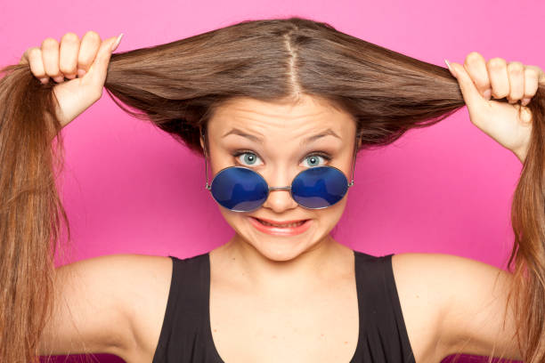 istock young funny girl with ponytail on pink background 1133781041