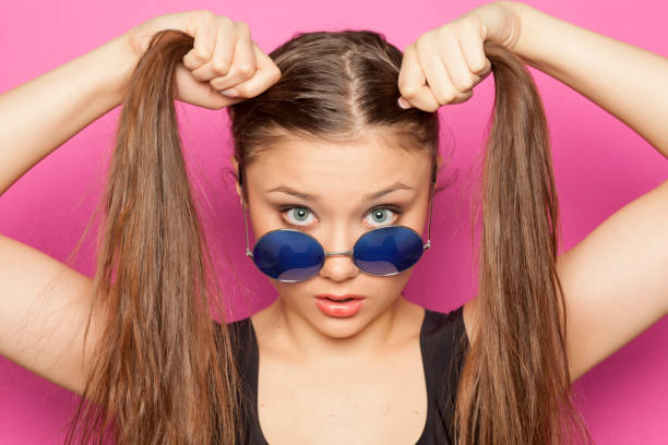 istock young funny girl with ponytail on pink background 1133781046