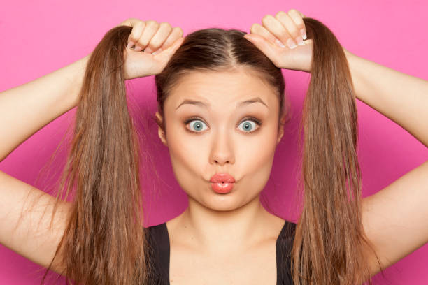 istock young funny girl with ponytail on pink background 1133781050