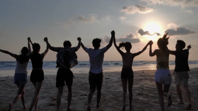 Silhouette group of friends having fun on the beach.Happy smiling friends running seaside sea ocean holiday travel.Vacations - iStock
