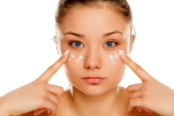 istock young girl applying face cream on white background 1133781863